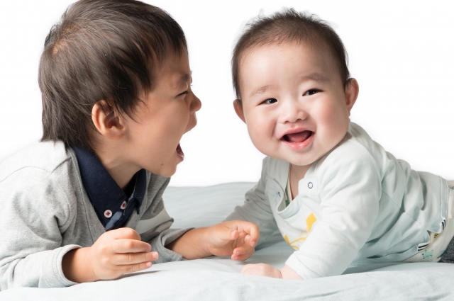 3歳くらいの男の子と赤ちゃんの笑顔の画像