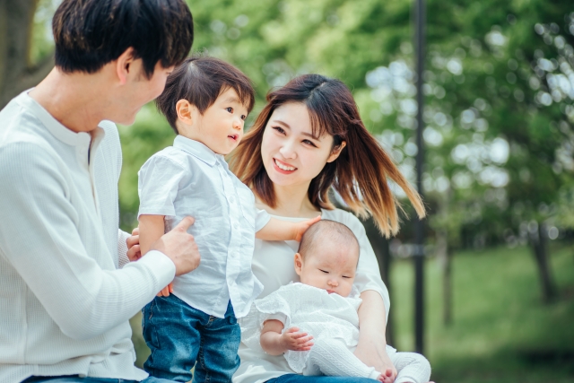 お揃いの服を着た家族4人の幸せそうな画像