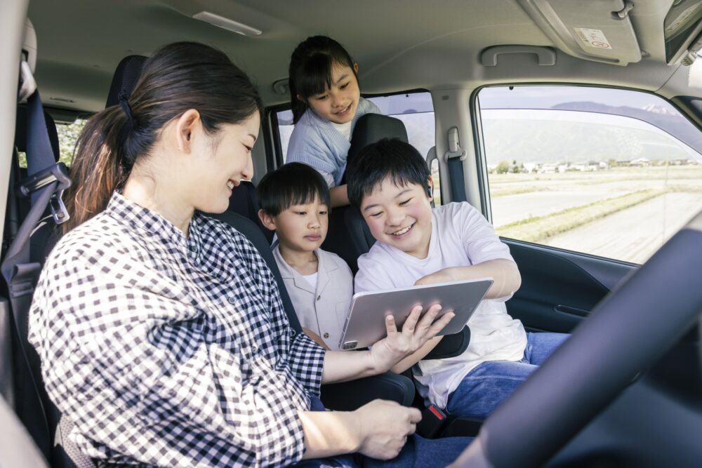 楽しそうに車で話している家族の画像