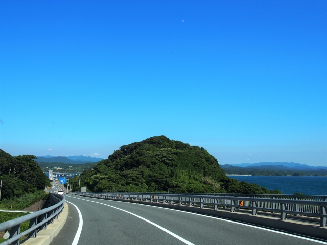 天気の良い海が見える道路の画像